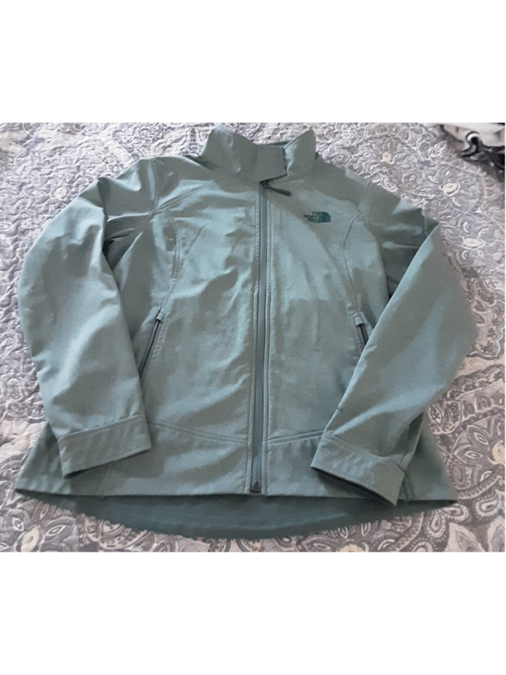 The North Face women’s WindWall full-zip jacket in a muted sage/gray-green color
